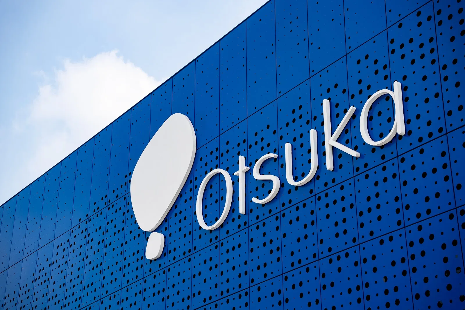 The Otsuka mark read out of the perforated aluminium facade at the Pocari Sweat factory