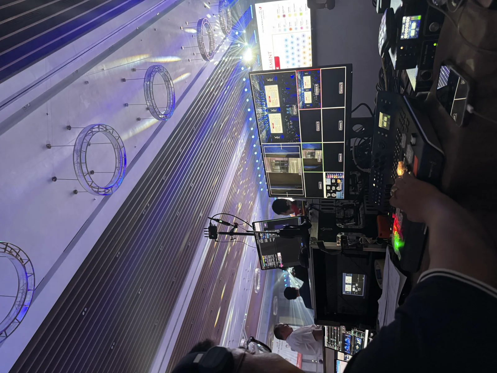 Vision mixer in hand, preview and programme across eight camera feeds
