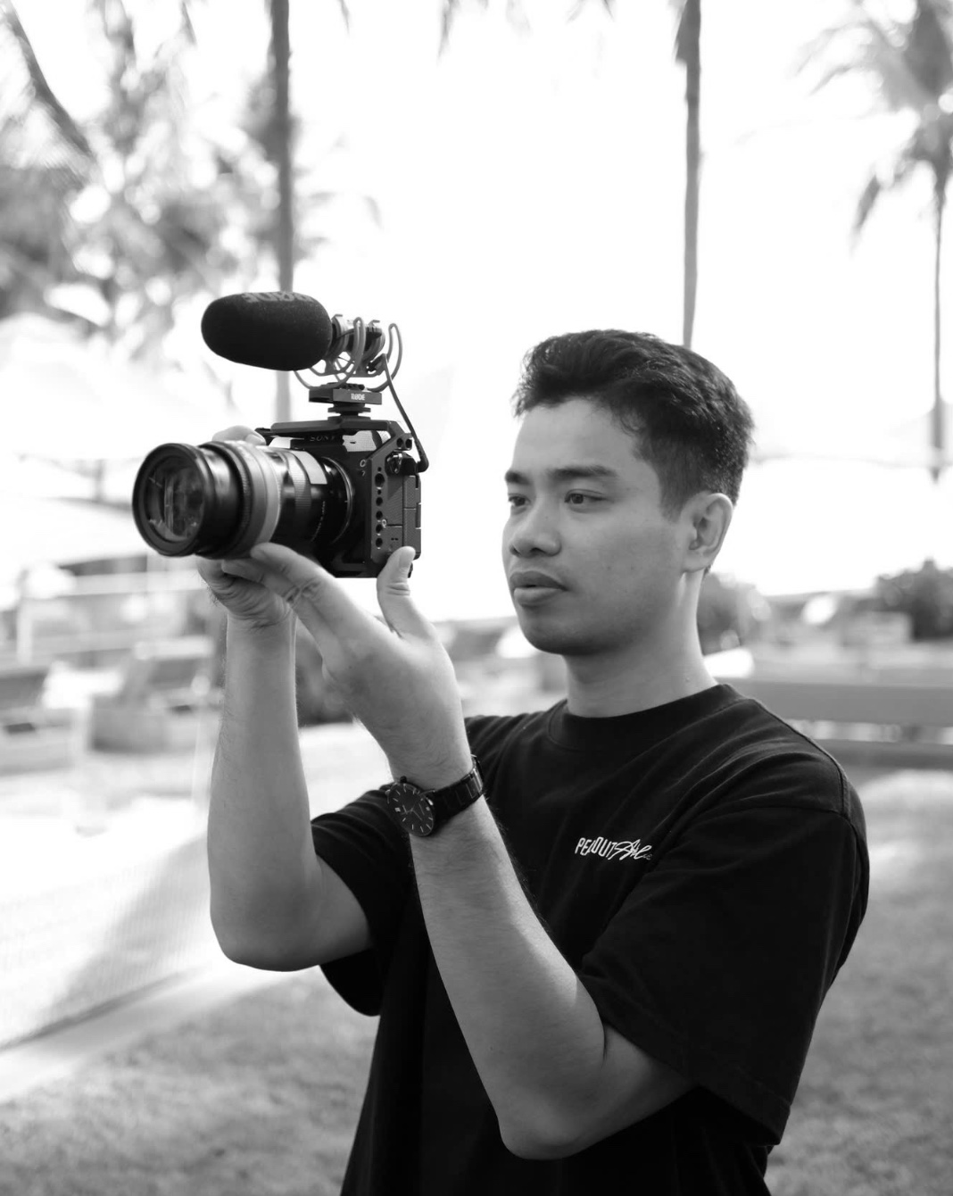 Duy Nguyen holding a Sony camera with a shotgun microphone on location for DNX Agency